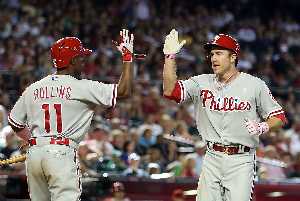 PHOENIX, AZ - MAY 12: Chase Utley #26 of the Philadelphia Phillies high-fives Jimmy Rollins #11 after scoring a 10th inning run against the Arizona Diamondbacks during the MLB game at Chase Field on May 12, 2013 in Phoenix, Arizona. Philly athletes