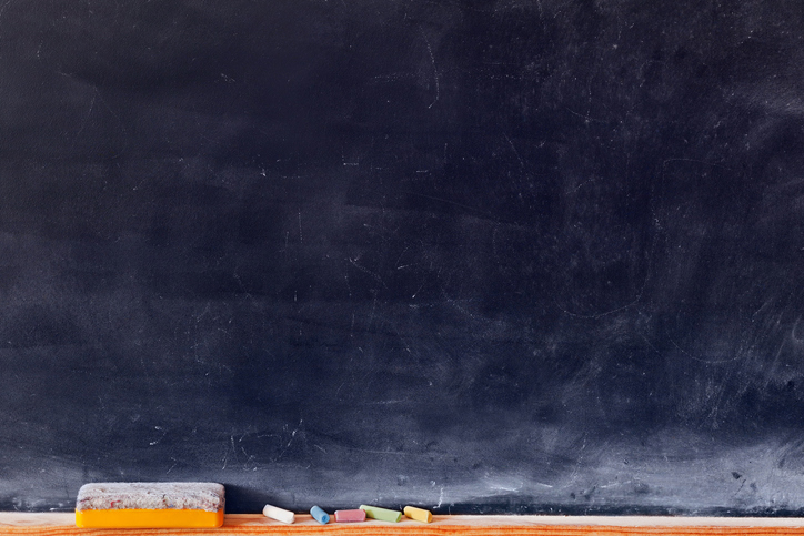 Blank blackboard with colored chalks and eraser. Horizontal composition