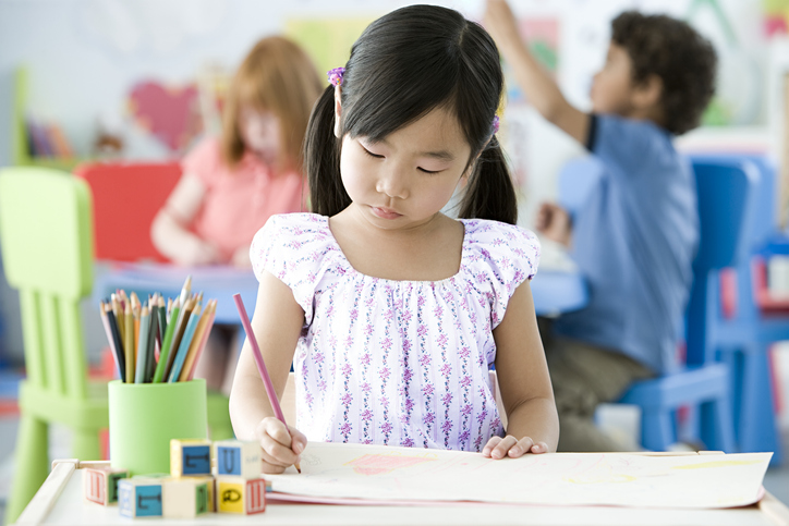 young Girl drawing at a desk