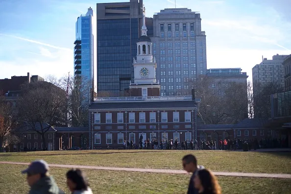 Tourists wait in line to see the Liberty Bell in front of the shuttered Independence Hall after the government shutdown 