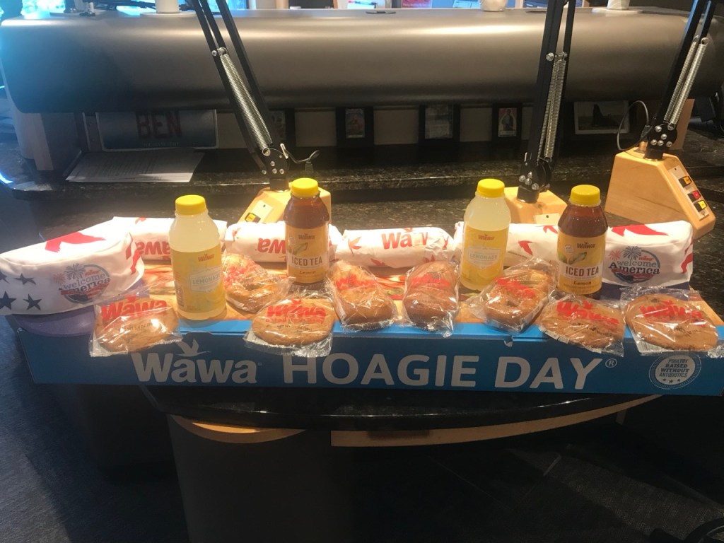 A photo of a box that says WAWA Hoagie Day with assorted WAWA items like lemonade and cookies. 