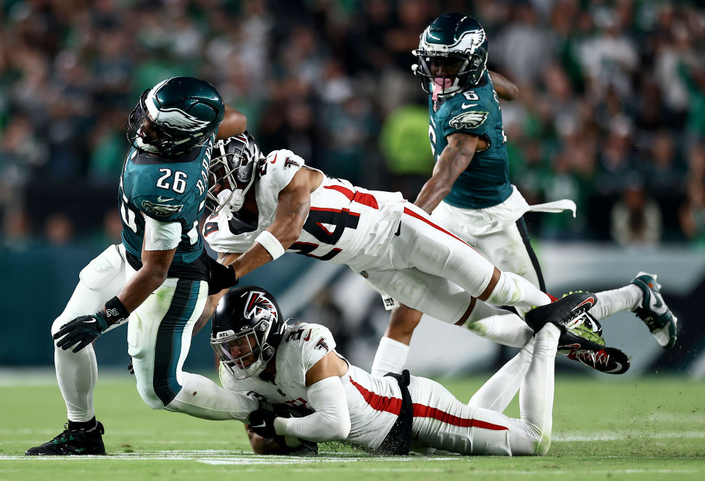 PHILADELPHIA, PENNSYLVANIA - SEPTEMBER 16: Saquon Barkley #26 of the Philadelphia Eagles is tackled by Jessie Bates III #3 and A.J. Terrell #24 of the Atlanta Falcons during the fourth quarter in the game at Lincoln Financial Field on September 16, 2024 in Philadelphia, Pennsylvania.